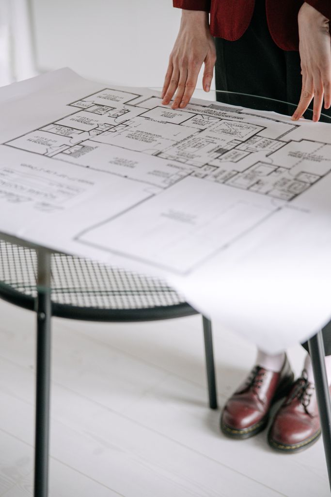 Detailed architectural floor plan on a table indoors with a focus on design in Sussex and London